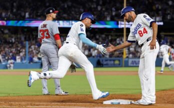Miguel Rojas, a bal oldalon, megkapja a Dodgers edzője, Chris Woodward kezét.