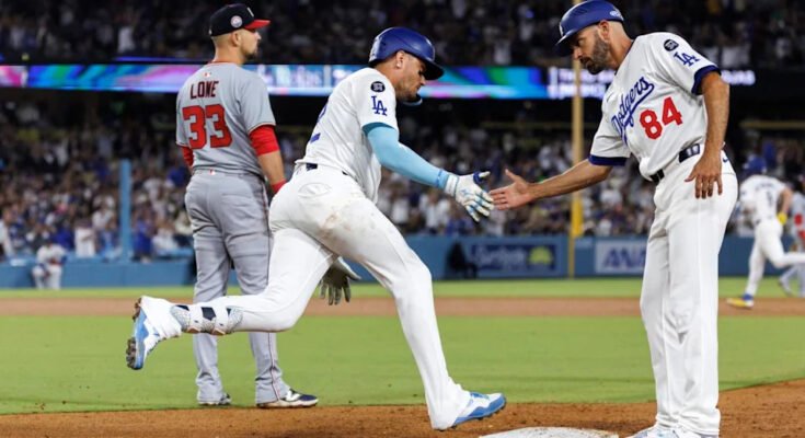 Miguel Rojas, a bal oldalon, megkapja a Dodgers edzője, Chris Woodward kezét.