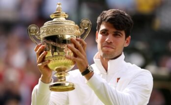 Carlos Alcaraz holds the Wimbledon Men's trophy aloft after his 2024 success.