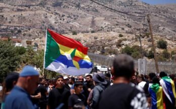 A Druze a Golan Heights faluban lévő határkerítés közelében vár, Izrael anctitált, Majdal Shams, míg a szíriai Druze, aki a napon átlépte a napot, mielőtt július 17 -én a szektáriánus véráramlás napjai után a szektáris véráramlás napjai után.