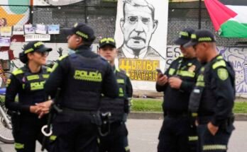 A rendõrség spanyolul áll egy szalaghirdetés előtt "Bűnös Uribe" Alvaro Uribe volt elnök ellenfelei a bíróságon kívül mutatják be, ahol a kolumbiai Bogota -ban, 2025. július 28 -án a tanúk hamisításával kapcsolatos tárgyalás során ítélet várható.