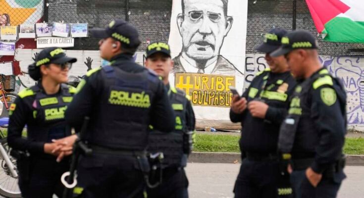 A rendõrség spanyolul áll egy szalaghirdetés előtt "Bűnös Uribe" Alvaro Uribe volt elnök ellenfelei a bíróságon kívül mutatják be, ahol a kolumbiai Bogota -ban, 2025. július 28 -án a tanúk hamisításával kapcsolatos tárgyalás során ítélet várható.