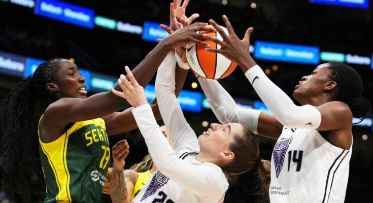 A Golden State Valkyries Kate Martin (20) kapusnak nehezen tartja fenn a birtoklást a Seattle Storm sztrájkoló, Ezi Magbegor ellen (balra), míg a Valkyries Temi Fagbenle (14) központja a WNBA mérkőzés második felében elérte a labdát Seattle -ben. A Valkyries ebben a szezonban debütált a 13. bajnoki csapatként.