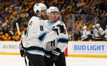 2025. április 14.; Nashville, Tennessee, Egyesült Államok; Az Utah Jégkorong Klub központja, Nick Schmaltz (8) a Clayton Keller (9) központi célját ünnepli a Nashville Predators ellen a második periódusban a Bridgestone Arénában. Kötelező hitel: Steve Roberts-Imagn Images