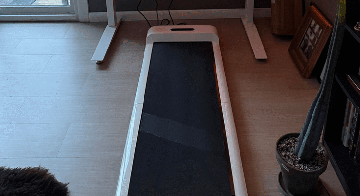 A C2 mini-tapis gördülő fehér gördülő tapis elülső kilátása, miközben részben egy emelt munkairoda alatt van