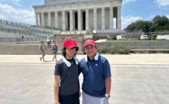 Jeffrey Pagulong (jobbra) és az ő 12 éves fia, Christof a Lincoln Memorial közelében, Washington DC -ben tartják, mindkettő piros baseball sapkát és fehér nyakhűtés -ventilátort visel.