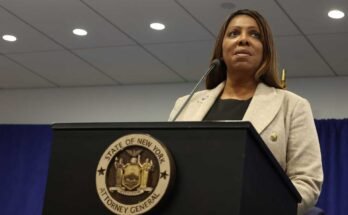 A New York -i főügyész, Letitia James, egy mikrofonnal felszerelt íróasztal mögött tartja, miközben 2025. január 8 -i sajtótájékoztatón beszél.